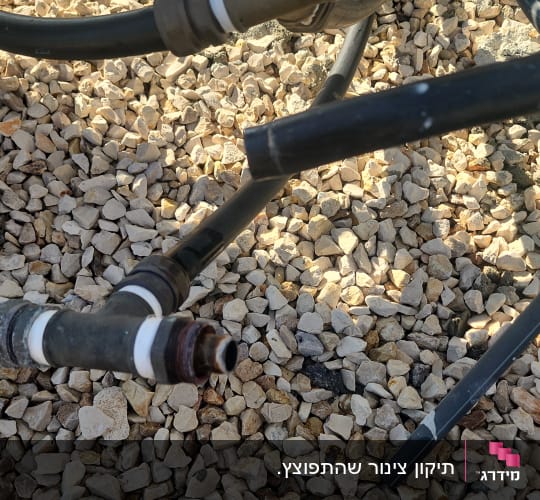 צינורות וחיבורים על מצע אבנים קטנות